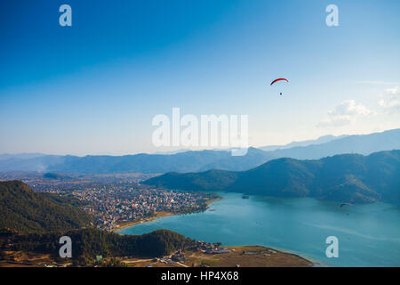 Gleitschirme von Sarangkot abheben und fliegen Sie über Pokhara, Nepal Stockfoto