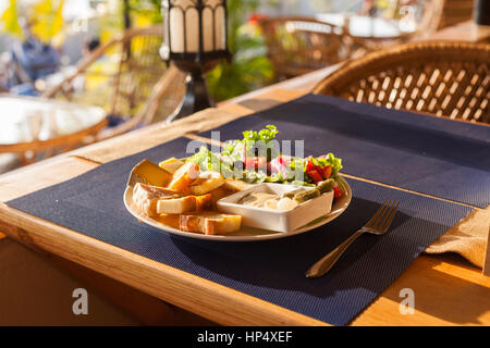 Eine französische Käse-Platte mit Tomme, Belkot und Saint-Marcellin Käse, Salat, Dijon-Senf, Essiggurken und Schalotten Stockfoto