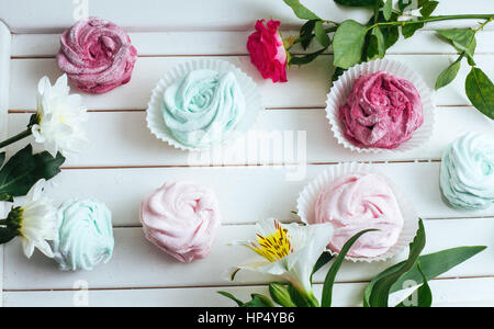 Rosa Marshmallows und schönen Blumen auf weißem Hintergrund wo Stockfoto