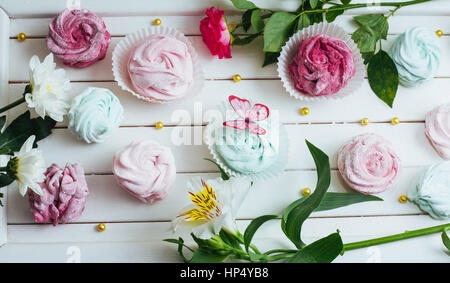 Rosa Marshmallows und schönen Blumen auf weißem Hintergrund wo Stockfoto