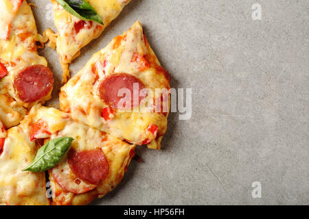 Pizzastücke auf konkreten Hintergrund, Lebensmittel-Draufsicht Stockfoto