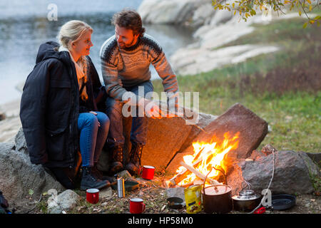 Paar sich Einander weiß Sitzend durch Lagerfeuer Stockfoto