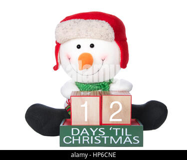 12 Tage bis Weihnachten hell Buche Holzblöcke mit Schneemann sitzt hinter trägt einen roten Hut grünen schwarze Stiefel isoliert auf weißem Hintergrund Schal Stockfoto
