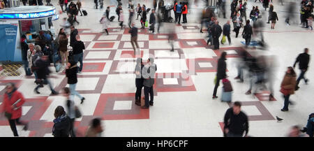 vollen Zug Hauptbahnhof Haupthalle, Bewegungsunschärfe vieler Menschen bewegen, paar in der Mitte noch auf der Suche in die Augen, um sie herum peopl Stockfoto