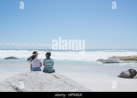 Schwarze und weiße Frauen Freunde chatten Noordhoek Beach Kapstadt Südafrika Stockfoto