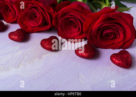 Burgunder Rosen auf lila Hintergrund. St. Valentine Day rotes Herz Grußkarte. Elegante Hochzeitseinladung. Kopieren Sie Raum. Verwendet, um Liebe, Leidenschaft symbolisieren Stockfoto