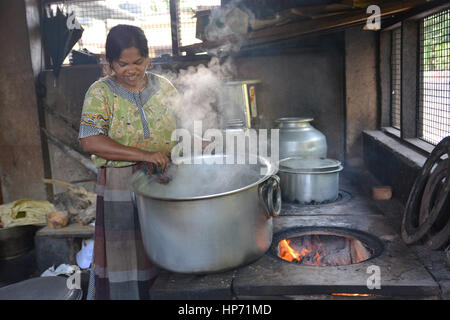 Mumbai, Indien - 28. Oktober 2015 - Frau Kochen Reis in einer traditionellen Küche in Indien am offenen Feuer Stockfoto