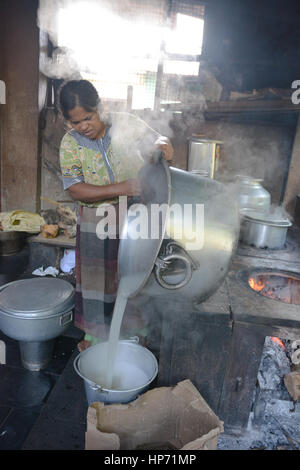 Mumbai, Indien - 28. Oktober 2015 - Frau Kochen Reis in einer traditionellen Küche in Indien am offenen Feuer Stockfoto
