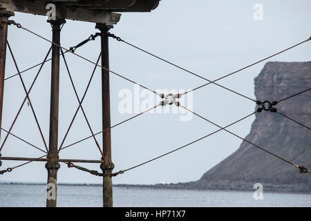 Struktur der viktorianischen Pier in saltburn, Beine zeigen und Versteifung Draht. warsett Hügel und Felsen im Hintergrund Stockfoto