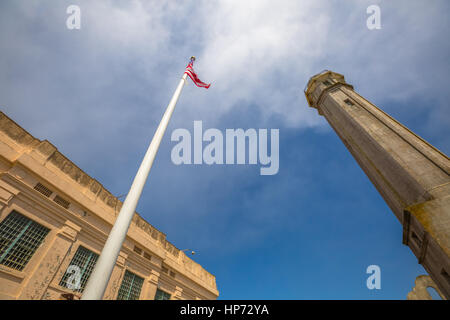 San Francisco Gefängnis Alcatraz in Eagle Plaza mit amerikanische Flagge winken und Leuchtturm, Grundriss gegen bewölkten Himmel bewegen. Konzept der amerikanischen frei Stockfoto