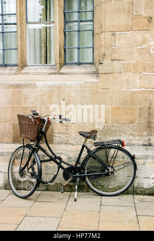 Einzelnes Fahrrad gelehnt Ziegelmauer eines alten Gebäudes in Cambridge Stockfoto