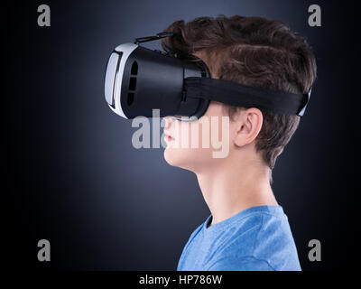 Glücklich teenboy tragen virtual-Reality Brille Filme oder Videospiele spielen. Fröhlich lächelnd Teenager auf der Suche in VR-Brille. Profil von chi Stockfoto