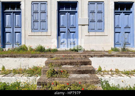 Blau aus Holz getäfelten Türen-Fensterläden der eröffnete im Jahre 1903 erbaut aus Stein auf der versunkene Hof des St. Nikolaos Stamatiou Grundschule geschlossen. Stockfoto