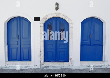 Drei blaue Holztüren an der weiß getünchten Wand von einem restaurierten klassizistischen Haus mit Blick auf die Uferpromenade von den wichtigsten Hafen im Zentrum der Stadt. Stockfoto