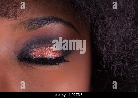 Bilden Sie in der Nähe bis geschlossene Auge einer afroamerikanischen Frau Stockfoto