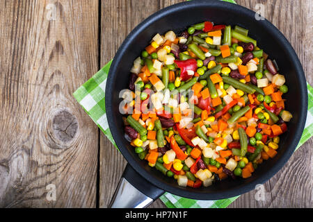 Gemischtes Gemüse in der Pfanne auf Hintergrund der alten Brettern. Studio Photo Stockfoto