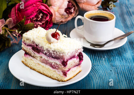 Stück Kuchen, Kuchen, Sahne, Kirschen, Schlagsahne auf blauem Hintergrund. Studio Photo Stockfoto