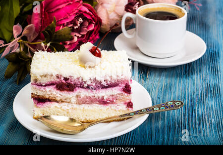 Stück Kuchen, Kuchen, Sahne, Kirschen, Schlagsahne auf blauem Hintergrund. Studio Photo Stockfoto