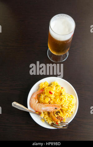 Portion Paella und Glas kaltes Bier. Madrid, Spanien. Stockfoto