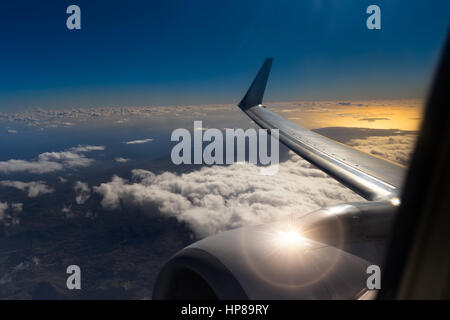 Blick aus dem Fenster eines Flugzeugs während Sonnenauf- oder Sonnenuntergang. Flügel Ansicht Sonnenuntergang Flugzeug, Sonnenuntergang Himmel Wolken Nacht. Flügel des Flugzeugs am Himmel. Flügel von einem airpla Stockfoto