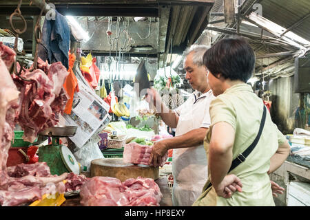 Fleischer hackt Fleisch für einen Kunden in seinem Stall in Chinatown, Kuala Lumpur, Malaysia Stockfoto