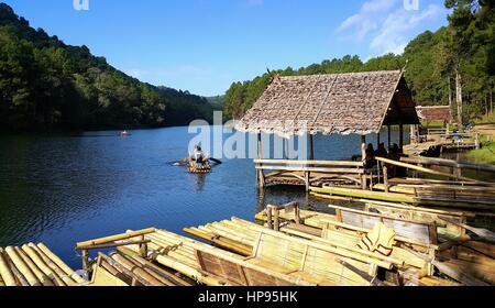 Touristen sitzen auf den Bambus Flößen schwebend in Pang Oung See (Pang Tong Reservoir) während der goldenen Sonnenaufgang morgen, Mae Hong Son, Thailand. Stockfoto