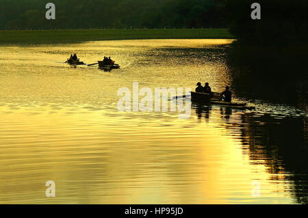 Touristen sitzen auf den Bambus Flößen schwebend in Pang Oung See (Pang Tong Reservoir) während der goldenen Sonnenaufgang morgen, Mae Hong Son, Thailand. Stockfoto