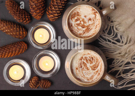 Becher mit cremigem Mokka (Kaffee und Schokolade) serviert auf Schiefer bei Kerzenschein in einem gemütlichen Zuhause Englisch Stockfoto