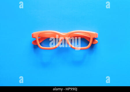 Flache Laien Mode Set: Sonnenbrille auf Pastell Hintergründe. Modesommer wird kommenden Konzept. Orange Brille auf blauem Hintergrund, Ansicht von oben. Trendige Fliesen Stockfoto