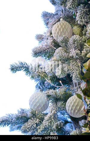 Weihnachtsbaum mit weißen Verzierungen auf einem weißen Hintergrund gefrostet Stockfoto