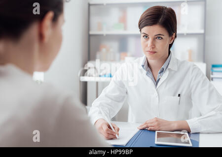 Ärztin mit einem Patienten im Büro treffen, gibt sie ein Rezept, um die Frau, Gesundheitswesen und Medizin-Konzept Stockfoto