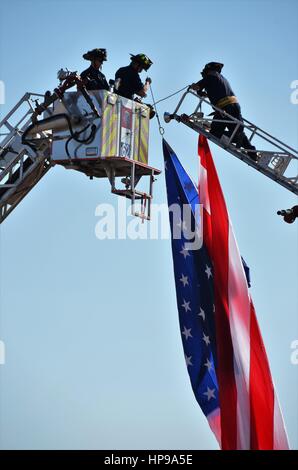 Feuerwehrleute, die eine amerikanische Flagge aufhängen Stockfoto