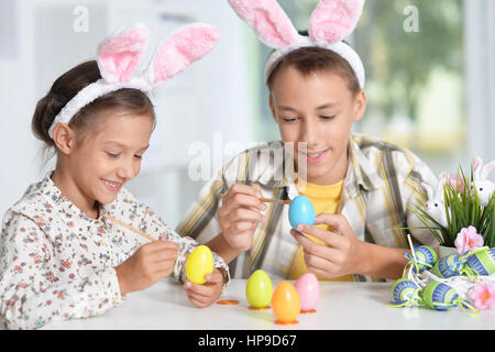 Geschwister, Bemalen von Ostereiern Stockfoto