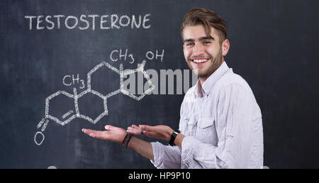 chemische Struktur der Testosteron-Molekül auf Tafel Hintergrund mit Mann vor ihm gezeichnet Stockfoto