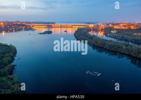 Abends Blick auf Dnjepr mit beleuchteten Dneproges Staudamm aus der Höhe von 100 m, Zaporozhye, Ukraine Stockfoto