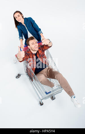 Frau mit Einkaufswagen mit glücklicher Mann Daumen auftauchen Stockfoto