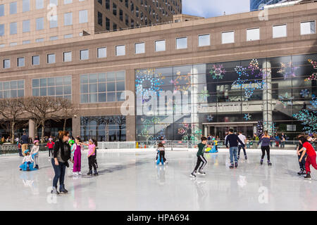 Schlittschuhläufer genießen die Eisbahn an Brookfield Ort an einem warmen Wintertag in New York City. Stockfoto