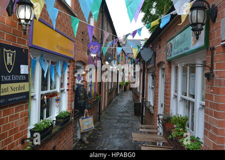 Geschäfte in der Gauntlet, St Johns Square, Glastonbury, Somerset Stockfoto