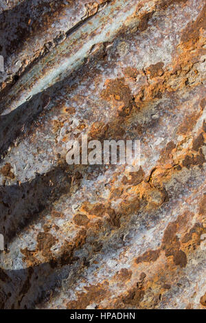 Nahaufnahme von verrosteten Rohr mit Schatten von Kämmen, das Wasser beschädigten und jetzt braun und grau mit abblätternden Metall ist. Stockfoto