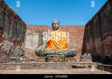 Große Buddha Statue an der teilweise restaurierten Ruinen von Wat worachet tharam in der antiken Stadt Ayutthaya, Thailand Stockfoto