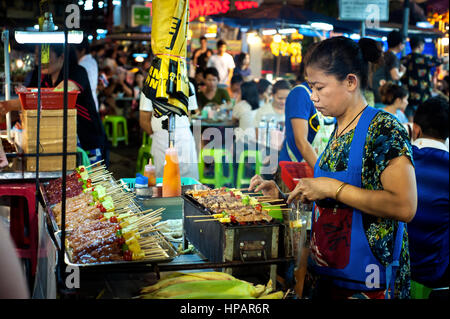 CHIANG MAI, THAILAND - Juni 2015 - eine Thai Lady Grills aufgespießt Fleisch am Samstag nacht Wua Lai Road Street Market, Chiang Mai, Thailand Stockfoto