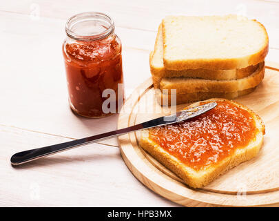 Frischen Toast mit hausgemachten Aprikose Marmelade auf Schneidebrett Stockfoto