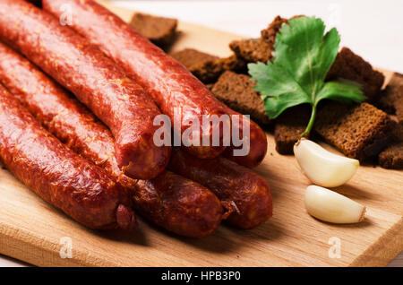 Geräucherte Salami Wurst mit Croutons, Knoblauch und Peperoni auf Schneidebrett Stockfoto