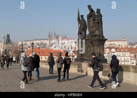 Touristen gehen vorbei die Statuen der Heiligen Norbert, Wenzel und Sigismund auf der Karlsbrücke in Prag Tschechische Republik Stockfoto