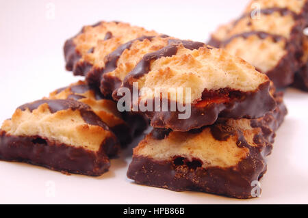 Haufen von Spritzgebäck mit Marmelade und Schokoladenglasur auf weißem Hintergrund. Stockfoto