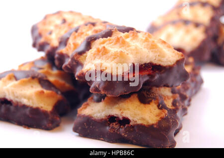 Haufen von Spritzgebäck mit Marmelade und Schokoladenglasur auf weißem Hintergrund. Stockfoto