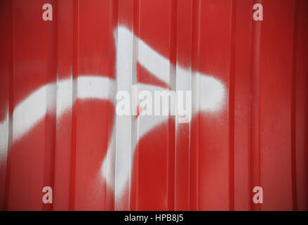 Weißer Pfeil auf rot gerippt Wand Hintergrund. Rot Metall-Container-Wand mit weißer Pfeil hautnah. Roten abstrakten Hintergrund. Stockfoto