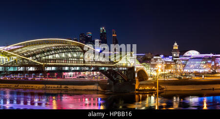 Nacht-Winterpanorama von der Moskwa-Ufer: Fußgängerbrücke Bogdan Khmelnitsky, Kiyevskaya Bahnhof, Stadt Moskau, Radisson Slavyans Stockfoto