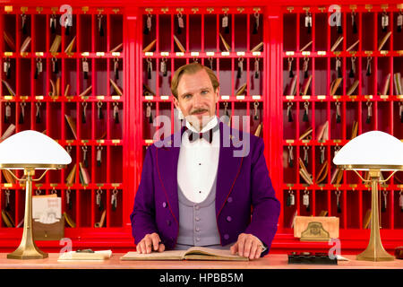 Monsieur Gustave H. (Ralph Fiennes) die legendäre Concierge an der Rezeption in "The Grand Hotel in Budapest" (2014) unter der Regie von Wes Anderson. Stockfoto