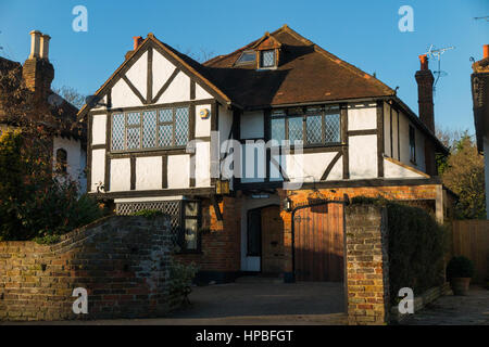 Mock Tudor schwarz-weiß 1930 Haus mit Garage und eine Fahrt in Esher, Surrey. VEREINIGTES KÖNIGREICH. Fotografiert an einem sonnigen Tag mit Sonne und blauer Himmel. Stockfoto